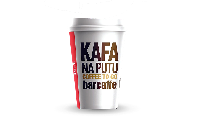 Na slici je čaša kafe za poneti sa natpisom „Kafa na putu“.